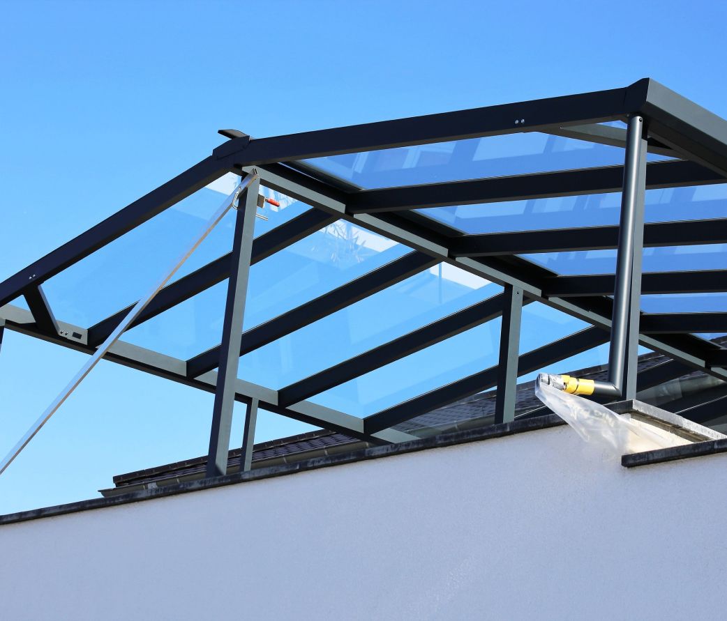 Modernes Dach aus Metallrahmen und Glas, das für Helligkeit und stilvolle Architektur sorgt.