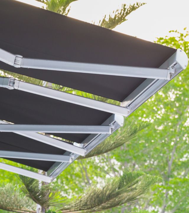 Nahaufnahme eines schwarzen Markisen mit einem Baum im Hintergrund, der eine ruhige Atmosphäre schafft